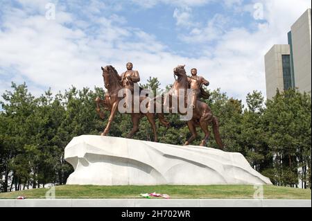 Bronzestatuen von Kim Il-sung und Kim Jong-il, die vor dem Mansudae Art Studio in Pjöngjang, Nordkorea, reiten. Stockfoto