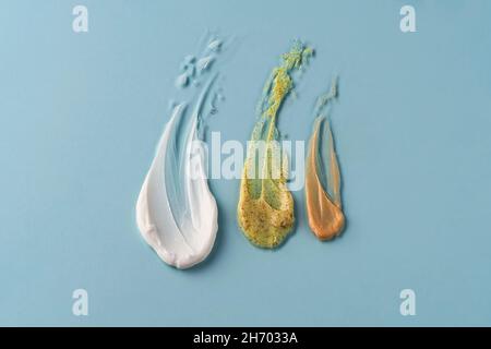 Cremefarbene Proben auf blauem Hintergrund. Cremige Textur isoliert. Stockfoto