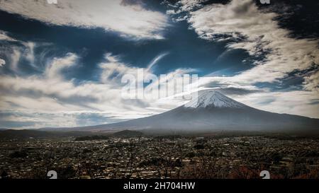 Der Berg Fuji und die Stadt Fujiyoshida, Japan, von einem nahe gelegenen Hügel aus gesehen. Stockfoto