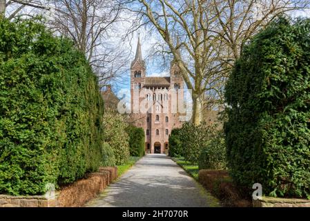 HOEXTER, DEUTSCHLAND - 04. Apr 2021: Der von Hecken gesäumte Eingang zum Westwerk von Schloss Corvey in Hoexter in Deutschland Stockfoto