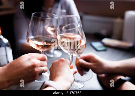 Freunde heben auf einer Heimparty Gläser Wein auf. Russland, Vorderansicht. Stockfoto