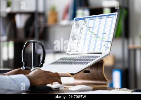 Geschäftsmann Arbeitet An Gantt-Diagramm Mit Computer Auf Office Desk Stockfoto