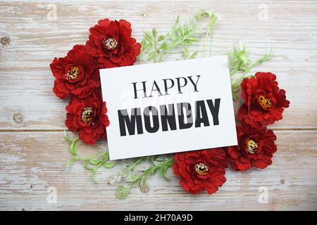 Happy Monday Text mit blühender Blume auf Holzhintergrund Stockfoto