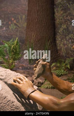 Eine Diorama-Ausstellung der Ureinwohner Amerikas, Ausstellung eines Mannes, der mit einem Felsen geschnitzt hat, im Science Museum. In Springfield, Massachusetts. Stockfoto