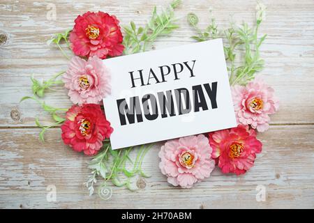 Happy Monday Text mit blühender Blume auf Holzhintergrund Stockfoto