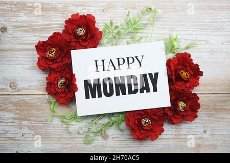 Happy Monday Text mit blühender Blume auf Holzhintergrund Stockfoto