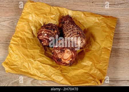 Drei ganze rohe Eddoes auf einer braunen Papiertüte, England, Großbritannien, Westeuropa. Stockfoto