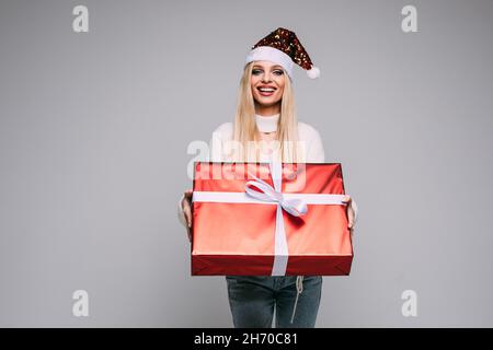 Hübsche junge Frau hält Weihnachtsgeschenk Stockfoto