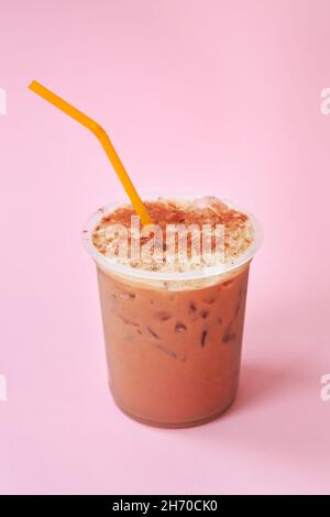 Ein Glas mit Eiskaffee-Cocktail, einem kalten erfrischenden Getränk oder einem Getränk mit Eis auf rosafarbenem Hintergrund Stockfoto
