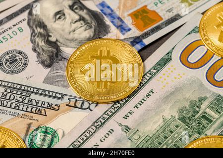 Metallglänzende Bitcoin-Krypto-Währungsmünzen auf US-Dollar-Scheinen. Stockfoto