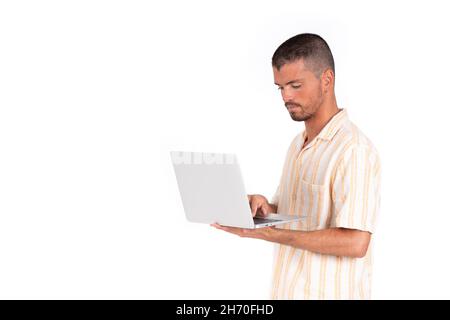 Kaukasischer junger Mann mit grauem Laptop auf weißem Hintergrund Stockfoto