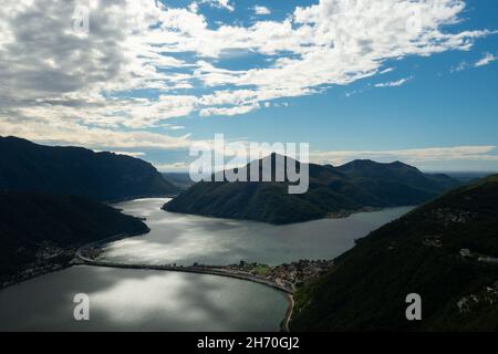 Lugano, Schweiz - Oktober 6th 2021: Blick vom Monte San Salvatore auf den Damm zwischen Melide und Bissone, der den See in zwei Teile trennt. Stockfoto