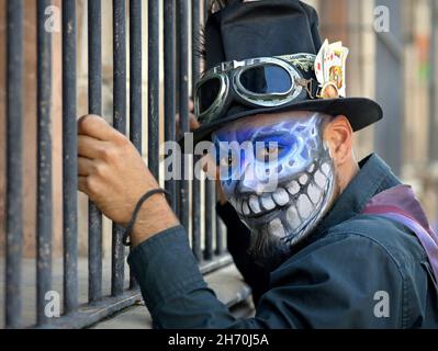 Kostümierter junger mexikanischer Yucatecan-Mann mit gruseliger blauer Gesichtsbemalung hält sich am Tag der Toten (Día de los Muertos) an starken Einbrechern fest. Stockfoto