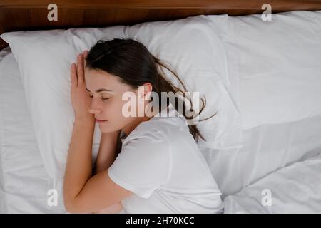 Nahaufnahme von oben Ansicht der Ruhe schöne junge kaukasische Frau 20s Jahre alt geht in komfortablen gemütlichen frischen weißen Bett schlafen genießen gesunden guten Schlaf Stockfoto