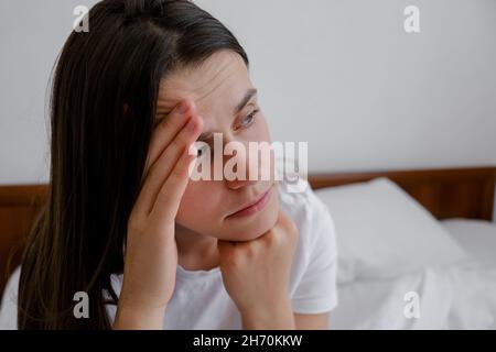 Nahaufnahme der depressiven Frau sitzen im Bett aufwachen Gefühl Stress Angst nach schlechtem Schlaf Albtraum Traum Konzept sitzen allein im Schlafzimmer Stockfoto