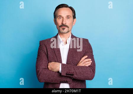 Foto von selbstsicher fokussierten reifen Mann gekreuzte Arme tragen roten Blazer isoliert blauen Hintergrund Stockfoto