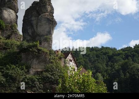 Berühmte Felsen mit Aussichtspunkt Fahnenstein über traditionellen deutschen Fachhäusern, Tüchersfeld, Pottenstein, Oberfranken, Bayern, Deutschland Stockfoto