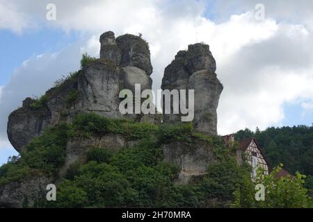 Berühmte Felsen mit Aussichtspunkt Fahnenstein über traditionellen deutschen Fachhäusern, Tüchersfeld, Pottenstein, Oberfranken, Bayern, Deutschland Stockfoto