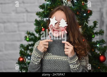 Lustiges Mädchen auf dem Hintergrund eines Weihnachtsbaums. Stockfoto