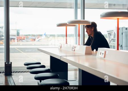 Mann, der in der Bibliothek sitzt und wegschaut Stockfoto