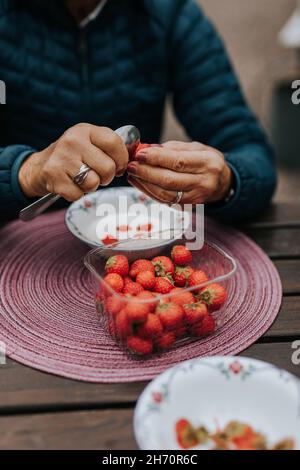 Die Hände der Frau hullten Erdbeeren Stockfoto