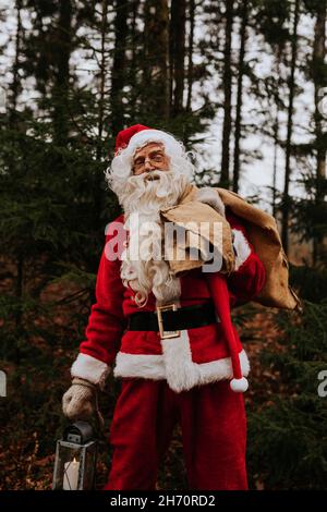 Mann mit Weihnachtsmann-Kostüm, der einen Sack trägt Stockfoto