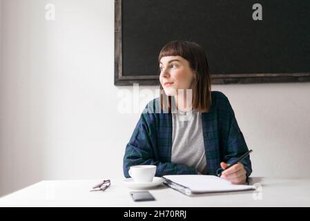 Junge Frau im Notizblock schreiben Stockfoto