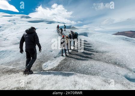 LOS GLACIARES NATIONALPARK, ARGENTINIEN - 26. JANUAR 2019: Eine Gruppe von Touristen wandert auf den Perito Moreno Gletscher Stockfoto