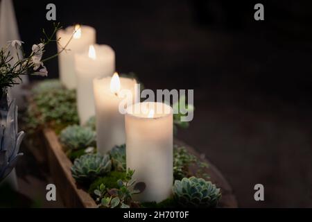 Dekoration mit Pflanzen und brennenden Kerzen Stockfoto