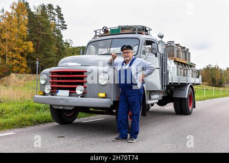 Milchmann steht vor dem Milchwagen Stockfoto