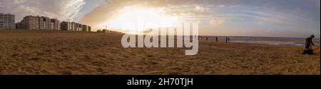 Lowangle Panorama des Strandes von Sint-idesbald mit viel Sand im Vordergrund im herbstlichen Abendlicht Stockfoto