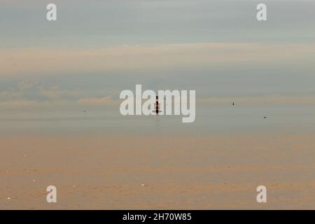 Einsame marine rote Signalboje in einem schönen blauen Meer, um die Schiffe zu warnen. Navigationsschilder, genauer gesagt, kein Fokus. Stockfoto