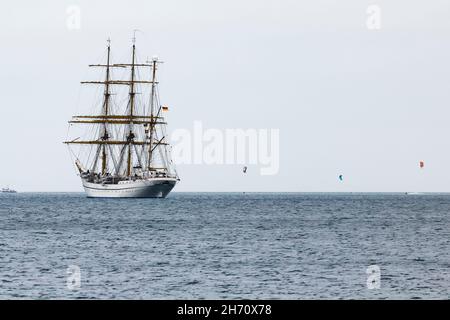 Laboe, Deutschland. 19th. November 2021. Begleitet von Kitesurfern segelt die Gorck Fock am Ostseebad Laboe vorbei. Nach jahrelanger kostspieliger Sanierung hat sich das Marineausbildungsschiff nun wieder auf eine Reise ins Ausland begeben. Vor den Kanarischen Inseln soll die Bundeswehr-Crew bei günstigen Wetterbedingungen trainieren. Quelle: Frank Molter/dpa/Alamy Live News Stockfoto