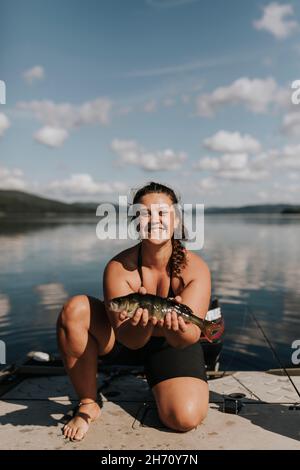 Lächelnde Frau mit Fisch Stockfoto