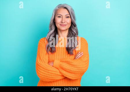 Portrait von attraktiven Inhalt fröhlich grauhaarige Frau gefaltet Arme isoliert über lebendige blaugrün Hintergrund Stockfoto