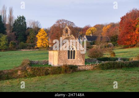 Sonnenaufgang über der Kirche St. Oswald im Herbst. Widford, Cotswolds, Oxfordshire, England Stockfoto