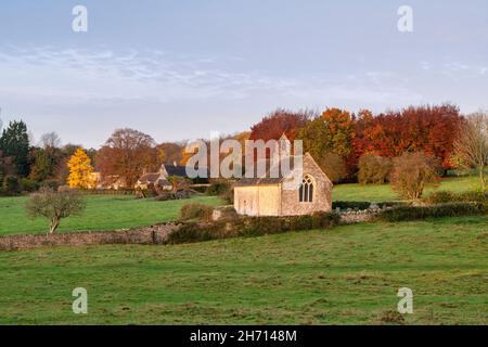 Sonnenaufgang über der Kirche St. Oswald im Herbst. Widford, Cotswolds, Oxfordshire, England Stockfoto