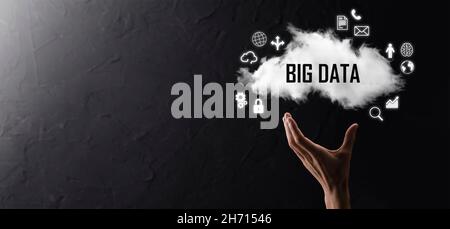 Geschäftsmann hält die Inschrift , Wort BIG DATA . Vorhängeschloss, Gehirn, Mann, Planet, Graph, Lupe, Zahnräder, Symbol für Cloud, Grid, Dokument, Brief, Telefon Stockfoto