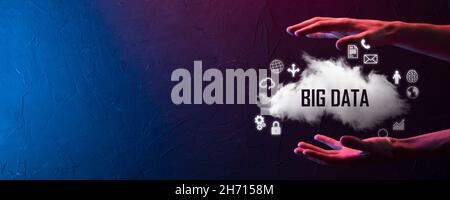 Geschäftsmann hält die Inschrift , Wort BIG DATA . Vorhängeschloss, Gehirn, Mann, Planet, Graph, Lupe, Zahnräder, Symbol für Cloud, Grid, Dokument, Brief, Telefon Stockfoto