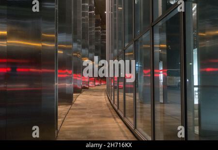 Die Lichter der Autos spiegeln sich in einem der hohen Gebäude der City of London wider. Stockfoto