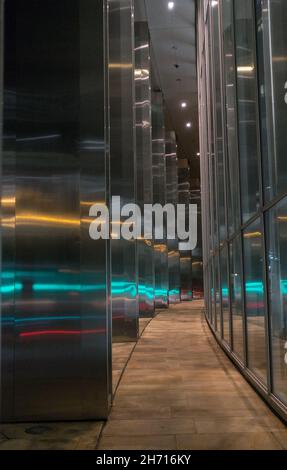 Die Lichter der Autos spiegeln sich in einem der hohen Gebäude der City of London wider. Stockfoto