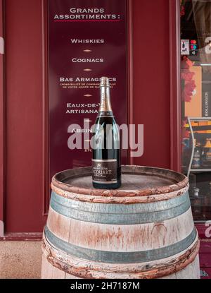 Delemont, Schweiz - 19. Oktober 2021: Eine Flasche Champagner auf einem Holzfass vor einem Spirituosengeschäft in Delemont Stockfoto