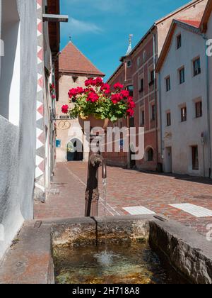 Glurns, Italien - 28. September 2021: Malerische mittelalterliche Stadtstraße von Glurns - Glurns in Südtirol mit Blick auf das Stadttor. Stockfoto