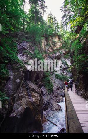 RAMSAU, DEUTSCHLAND - 26. Aug 2020: Ein erhöhter enger Fußweg mit Touristen neben der schönen Wimbachklamm mit Wasserfällen Stockfoto
