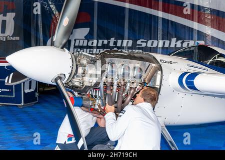 Ingenieure, die an dem Lycoming-Motor des Zivco Edge 540 V3-Rennflugzeugs von Pilot Martin Sonka bei der Red Bull Air Race-Serie auf der Rennbahn Ascot arbeiten Stockfoto