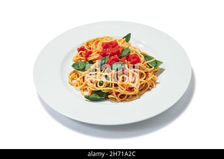 Italienisches Essen. Teller mit leckeren Nudeln mit Tomaten und Basilikumblättern isoliert auf weißem Hintergrund. Konzept der weltweiten nationalen Küche Stockfoto