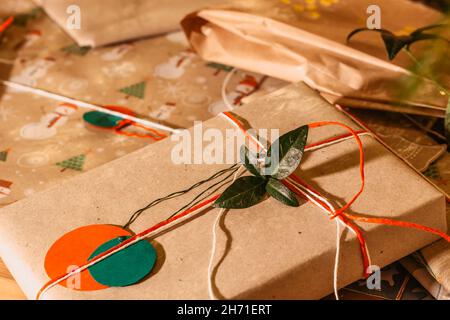 Weihnachten Zusammensetzung.Weihnachten Geschenke mit roten grünen Bändern und Baum Zweig Dekor.Geschenke verpackt in Handwerk recyceltes Papier und Seil Bogen.Winterurlaub Stockfoto