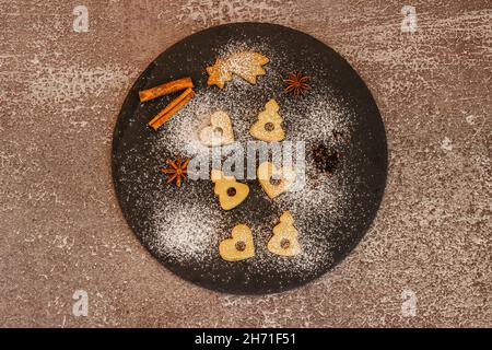 Leckere hausgemachte Kekse auf dunklen Teller.Weihnachts-Cookie-Muster.Winterferien Dessert Ornament Raum für Text.Weihnachten Gewürze.traditionelle Linzer Weihnachten Stockfoto
