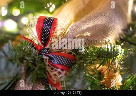 Festliches rot-blaues Weihnachtsband auf Stoff und Kiefer, verschwommener Hintergrund Stockfoto