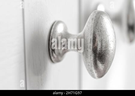 Nahaufnahme der Knöpfe an bemalten Küchen- und Schranktüren. Stockfoto